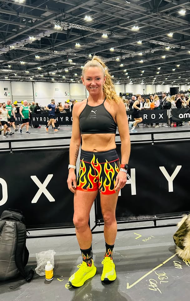 Sally Harrison at HYROX in her black race top and flame shorts