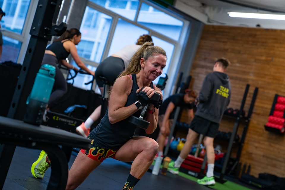 Sally performing a weighted lunge in black and flame-pattern kit